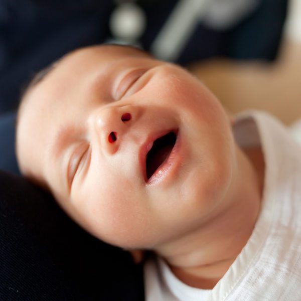 Portrait of sleeping newborn baby girl with smile.