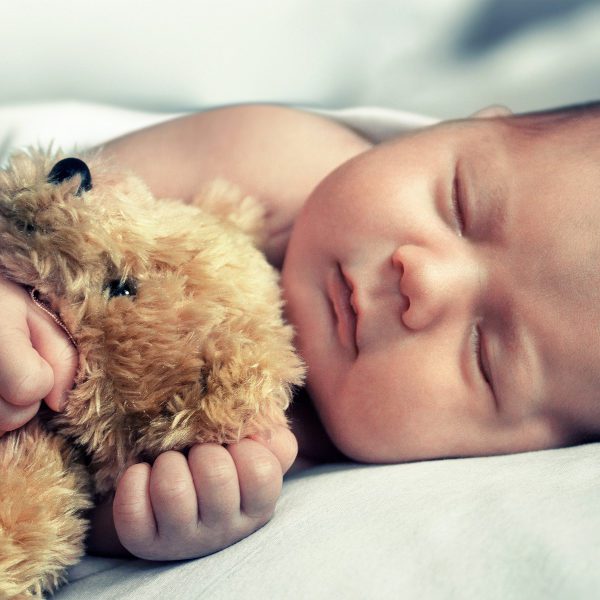 newborn baby sleep and hugs teddy